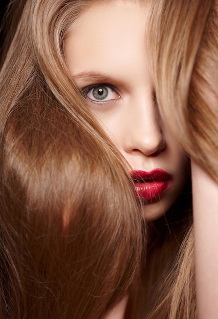 Red hair woman with red lips posing on camera