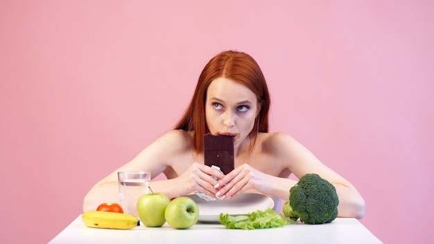 赤い​髪​の​拒食症​の​少女​が​貪欲​に​チョコレート​を​食べる​。​摂​食​障害​。​拒食症