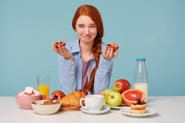 Red-haired happy funny woman has breakfast