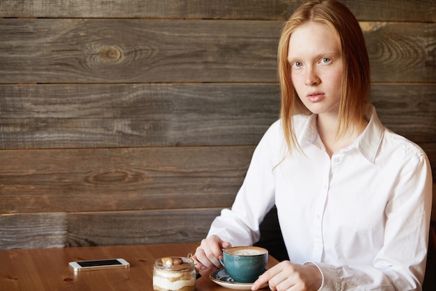 Red-haired woman sitting in cafe