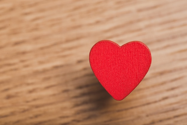 Красное сердце крупным планом на деревянный стол