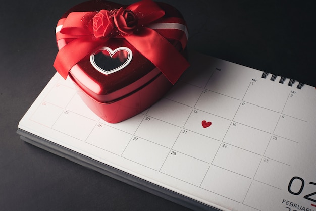 Free photo red heart in february 14 on the calendar with heart shaped gift box, valentine's day concept.