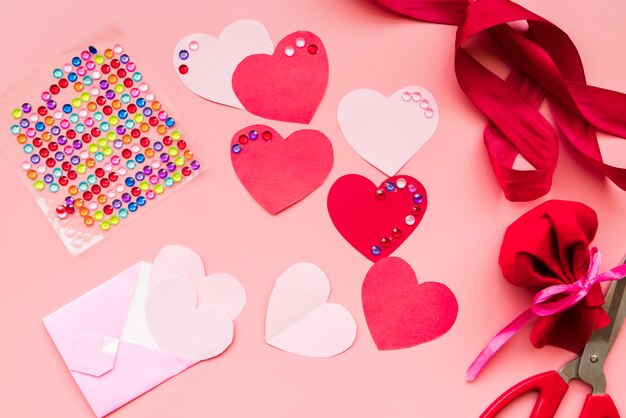 Red heart shape with ribbons on pink background