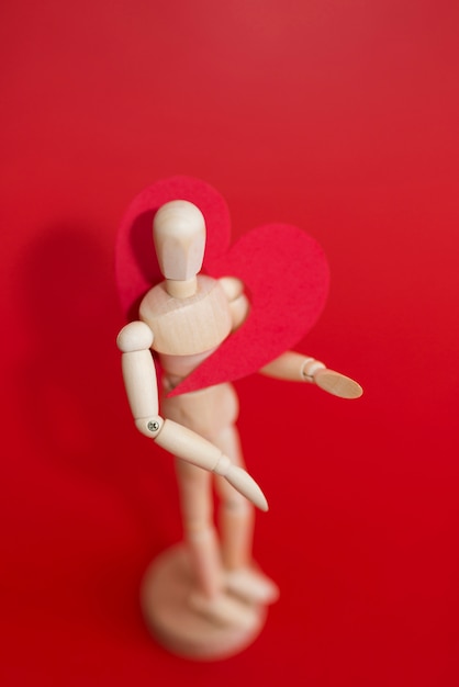 Red heart on wooden mannequin 