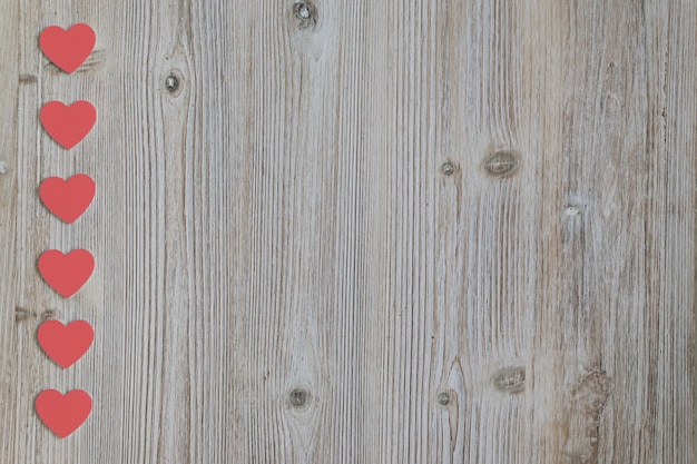 Free photo red hearts placed in column above a wooden table