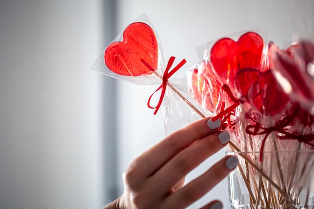 Red heartshaped lollipops on the counter of a candy store