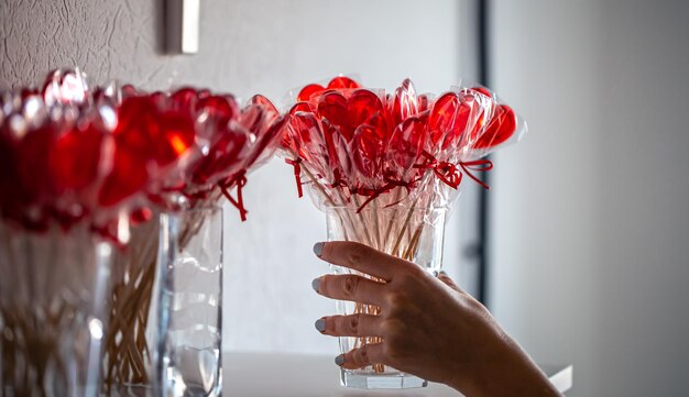 Red heartshaped lollipops on the counter of a candy store