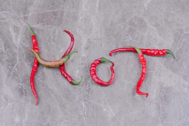 Red hot chili peppers isolated on marble surface