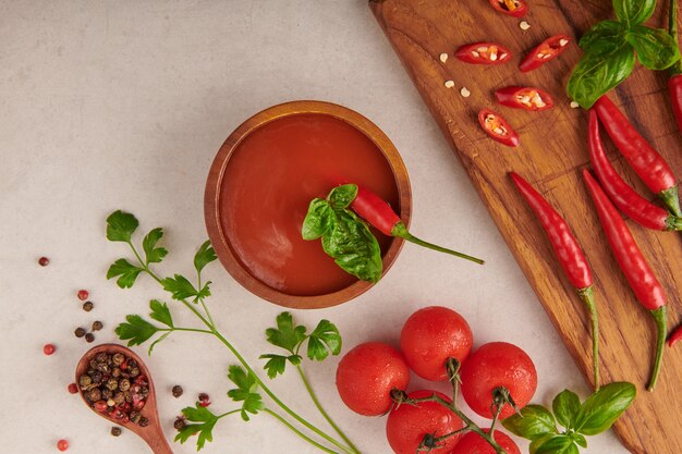 Red hot chilli sauce. tomato ketchup, chilli sauce, puree with chili pepper, tomatoes and garlic. on wooden cutting board on stone surface. top view.