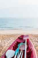 Free photo red kayak on sandy sea shore