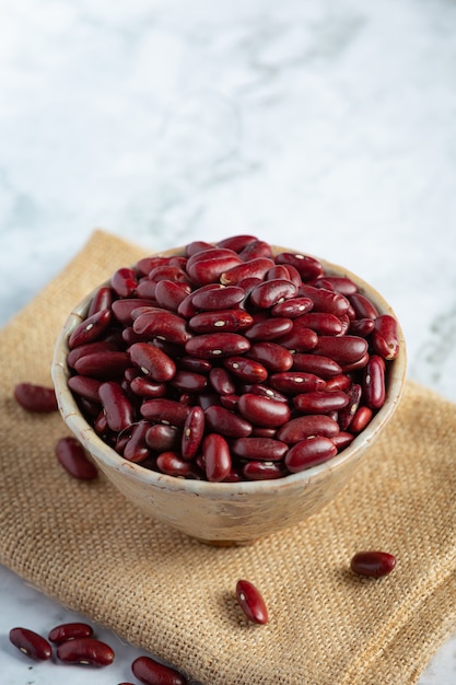 Free photo red kidney beans in a small bowl place on sack fabric