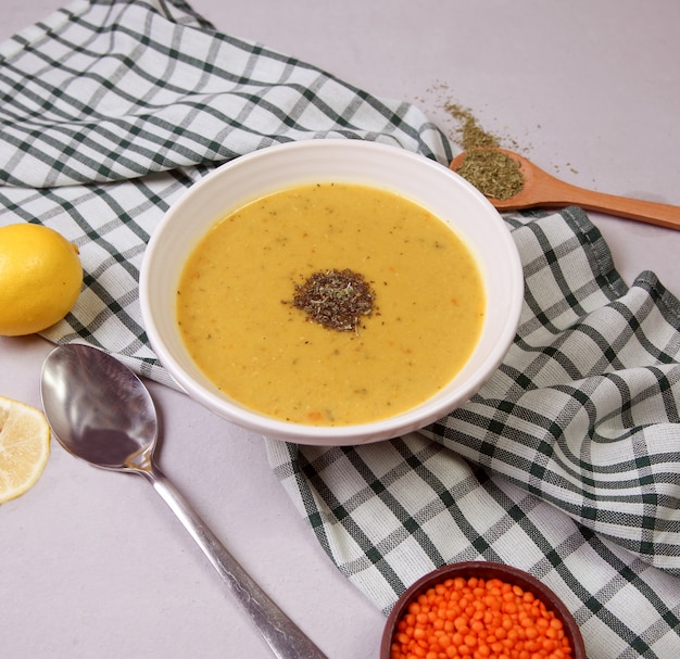 Free photo red lentil soup with herbs in the white bowl.