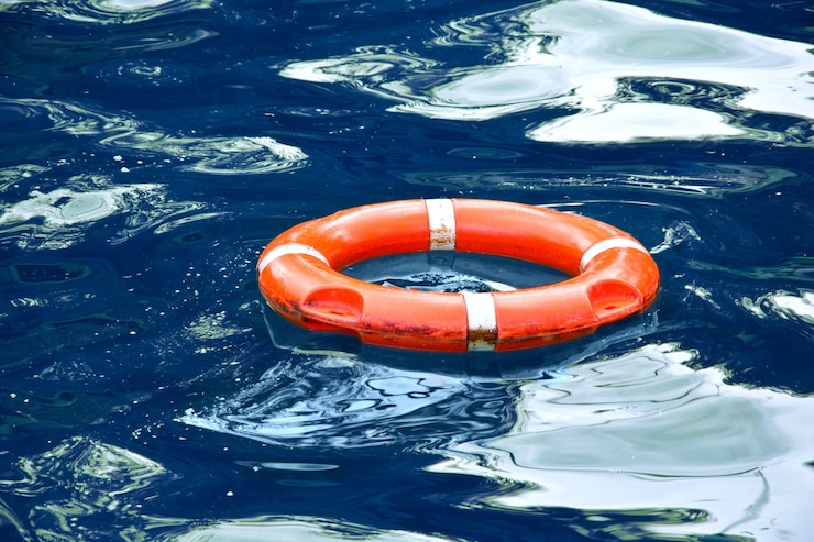 Free Photo red lifebuoy in blue water.