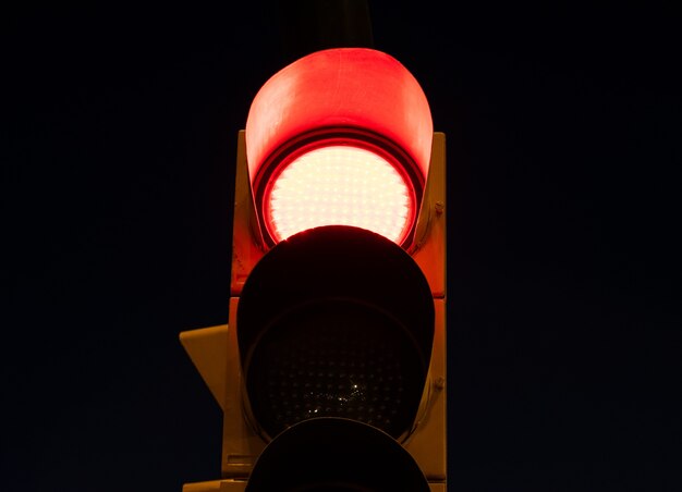 Красный свет на светофоре на улице ночью