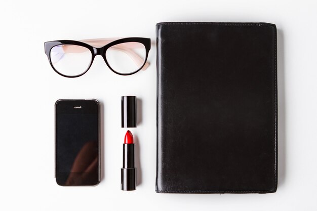 Красная помада очки телефон и ноутбук на белом фоне