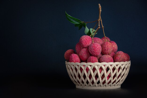 Red lychee fruit placed in a basket.