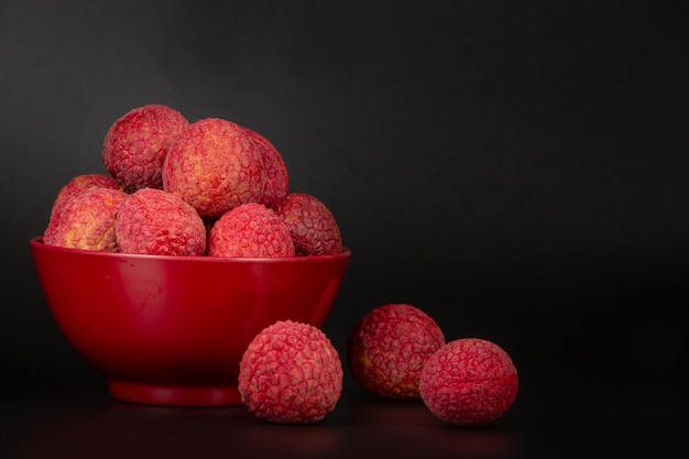 Red lychee fruit placed in a basket.