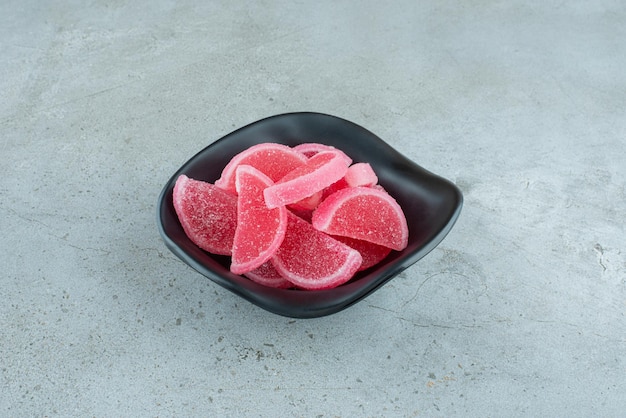 Red marmalade candies in black bowl. High quality photo