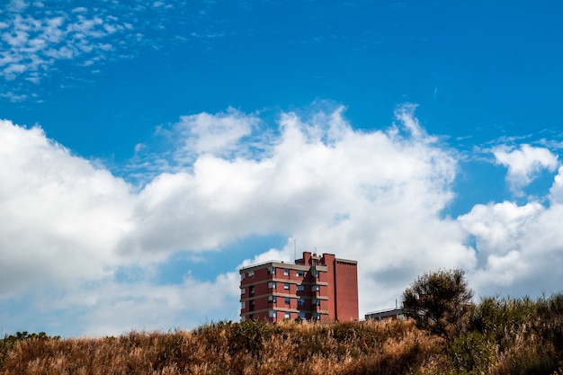 Red multi-story residential building and a cloudy sky