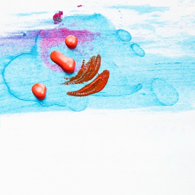 흰색 배경 위에 얼룩이 파란색 질감에 빨간 매니큐어 드롭 및 스트로크