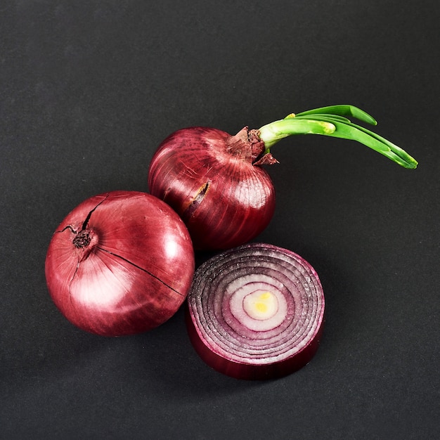 Free photo red onions whole, isolated on a black.