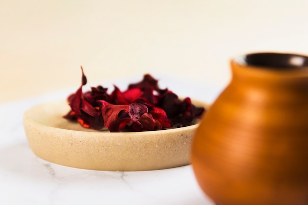 Red orchid flower petals with clay pottery