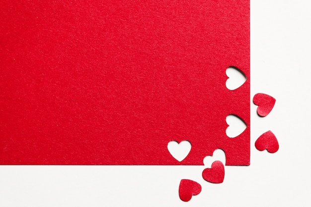 Бесплатное фото Красная бумага и вырезанные сердца