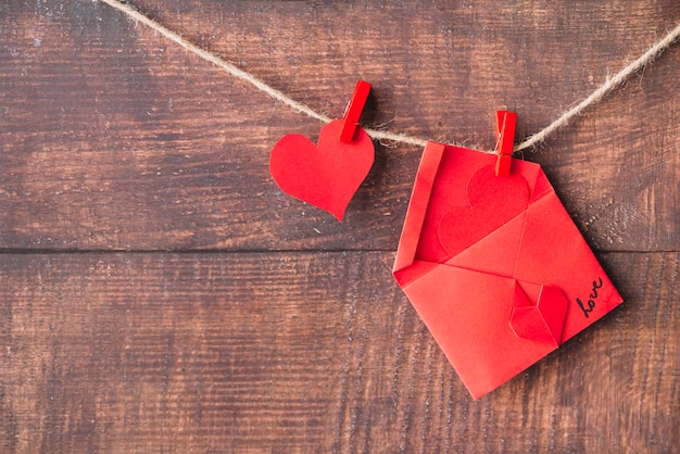 Red paper heart and envelope with pins hitching on twist