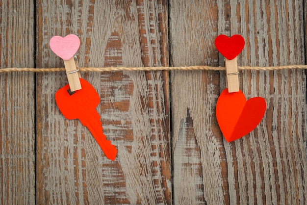 Free photo red paper heart hanging on wood background .