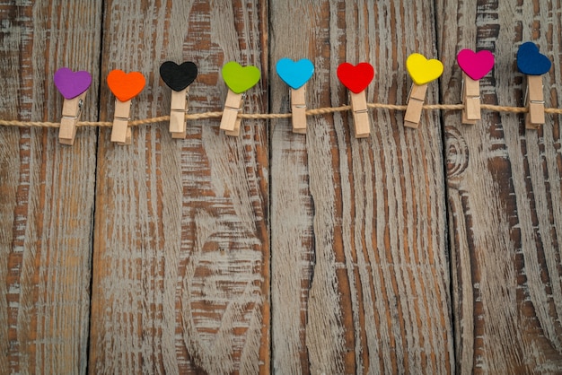 Red paper heart hanging on wood background .