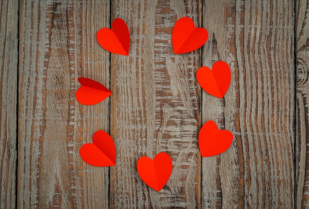 Red paper origami heart  on wood background .