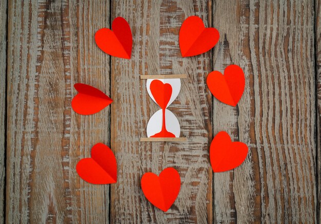 Red paper origami heart  on wood background .