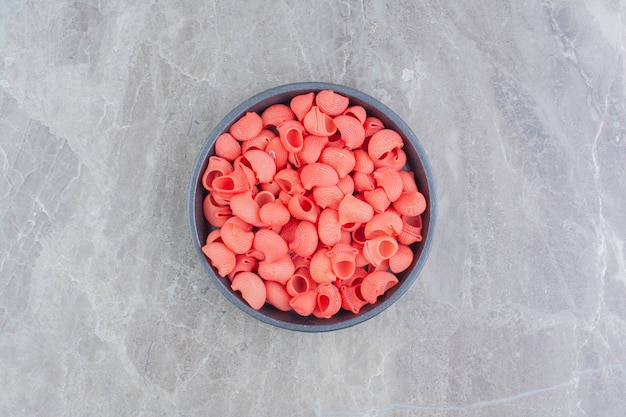 Free photo red pastas in a black metallic cup on the marble