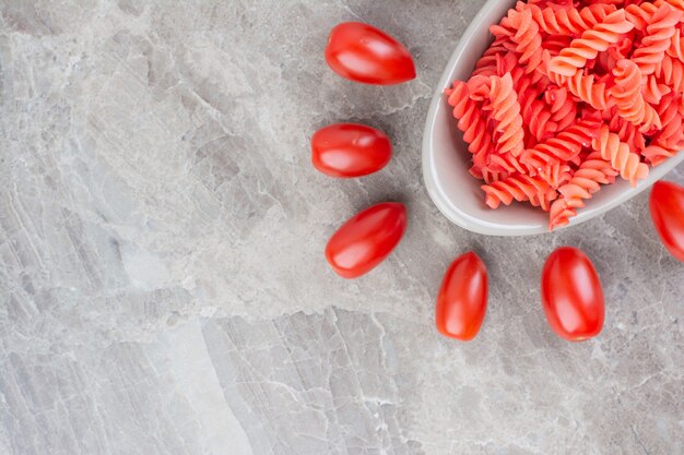 Красные пасты в томатном соусе с помидорами черри вокруг.