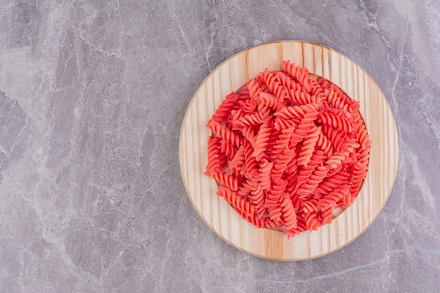 Foto gratuita paste rosse in un piatto di legno sul marmo