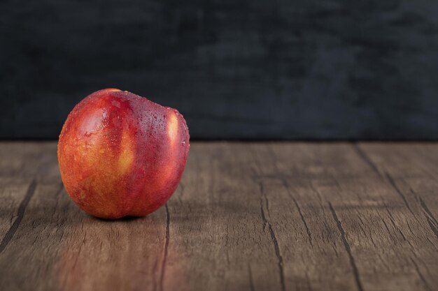 Red peaches isolated on wooden board.