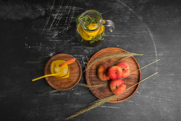 Red peaches with a glass of juice and lemonade in the jar, top view