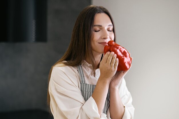 Red pepper. Long-haired young woman holding red pepper in hands