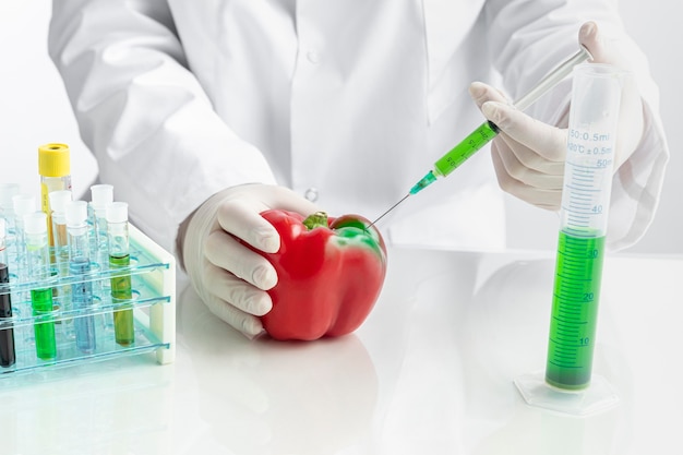 Red pepper and syringe filled with green chemicals