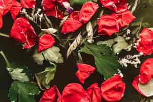 Free photo red petals with leaves in black water