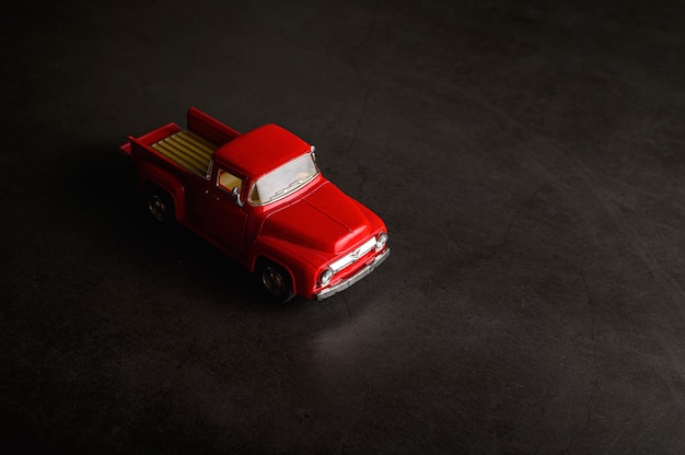 Free photo red pickup model on the black floor