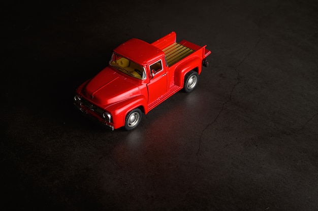 Free photo red pickup model on the black floor