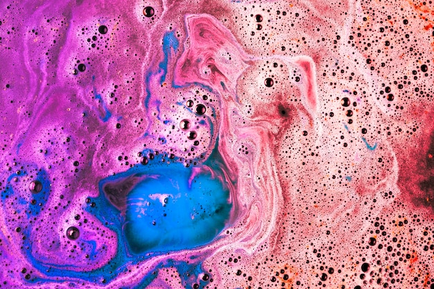 Red; pink; and blue bathbomb dissolve in water