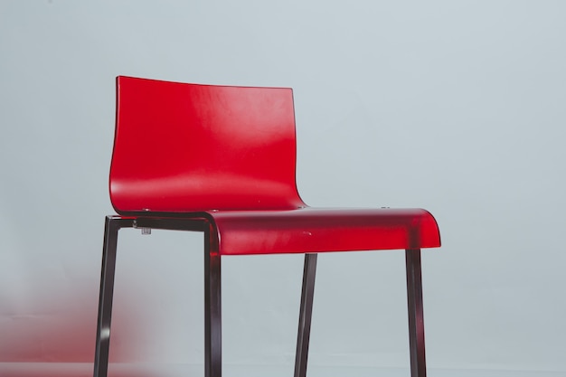 Red plastic chair on white wall