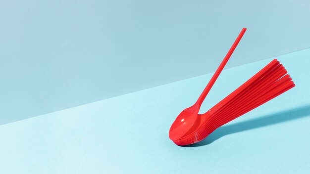 Red plastic spoons copy space