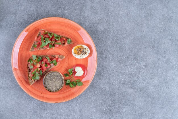 A red plate with boiled egg and toasts 