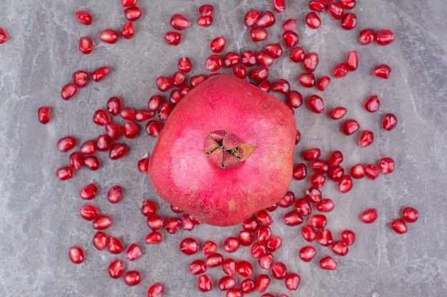 무료 사진 붉은 석류와 씨앗 돌 배경입니다.