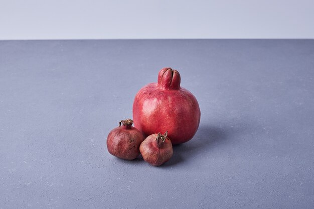 Red pomegranates isolated on blue.