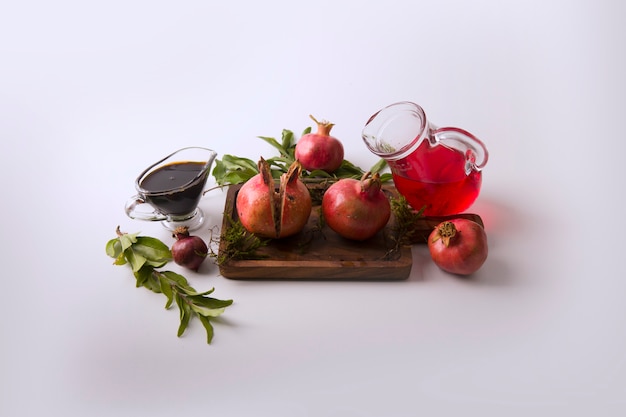 Red pomegranates and sauce in the wooden board