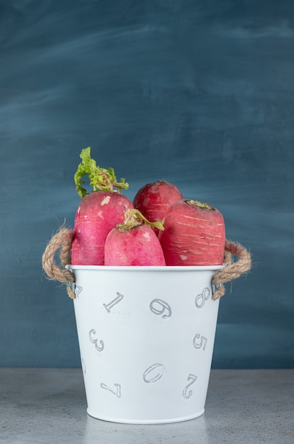 Free photo red radish and leaves in on a gray background. high quality photo